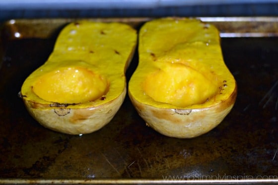 two halves of butternut squash with skin on baking in the oven