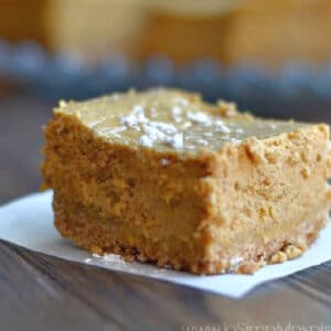 slice of pumpkin cheesecake bars on a white napkin