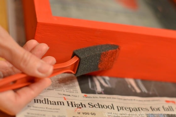 a piece of wood frame being painted red
