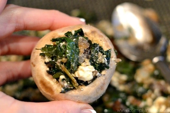 Uncooked stuffed mushrooms held in fingers