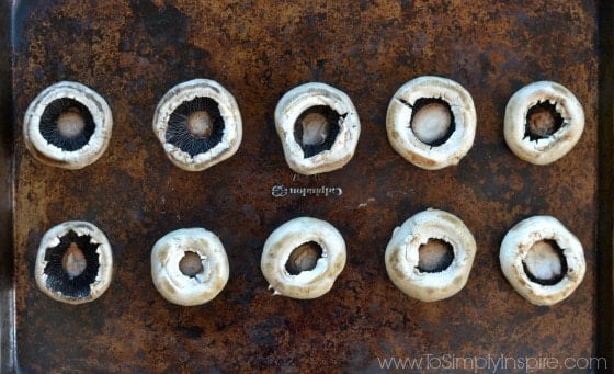 fresh mushroom caps on a baking sheet