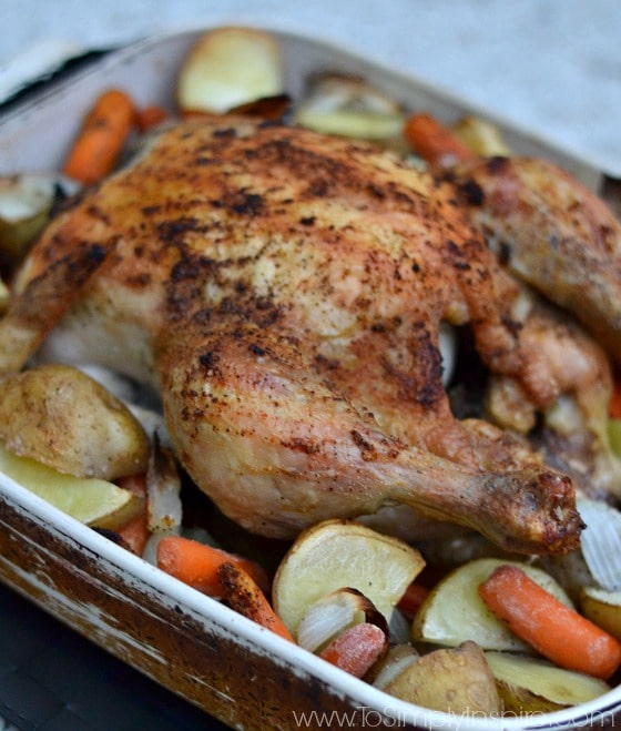 A close a whole roasted chicken in a glass baking dish