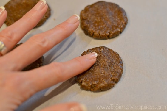 woman hand pressing gingerbread cookie