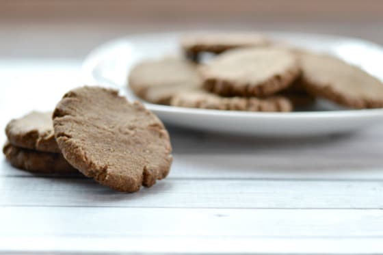 a plate full of gingerbread cookies with three cookies on the table 