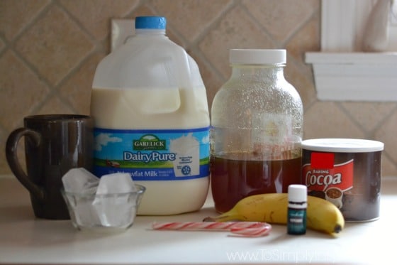 a gallon of milk, jar of honey, banana, cocoa powder on a counter
