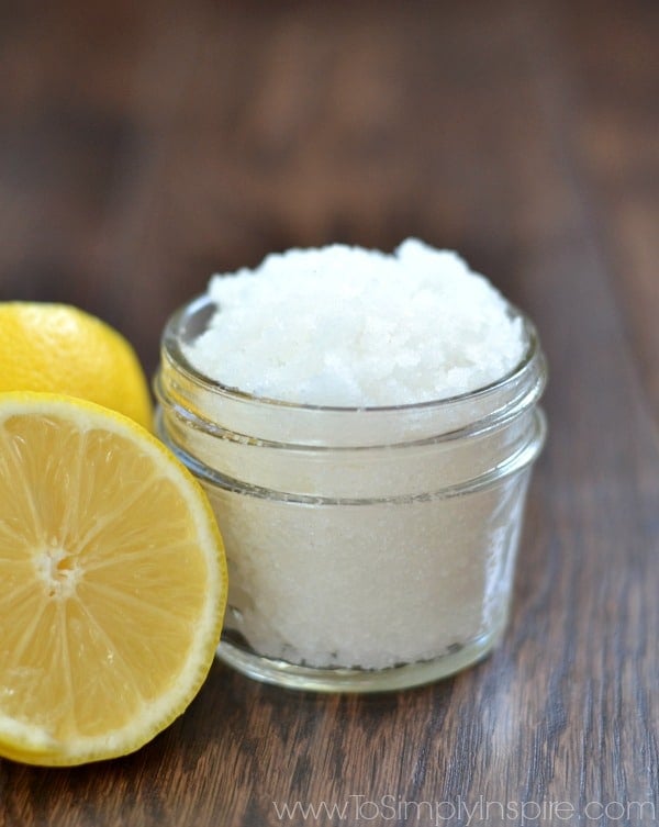 a small mason jar with lemon sugar scrub and a half a lemon beside