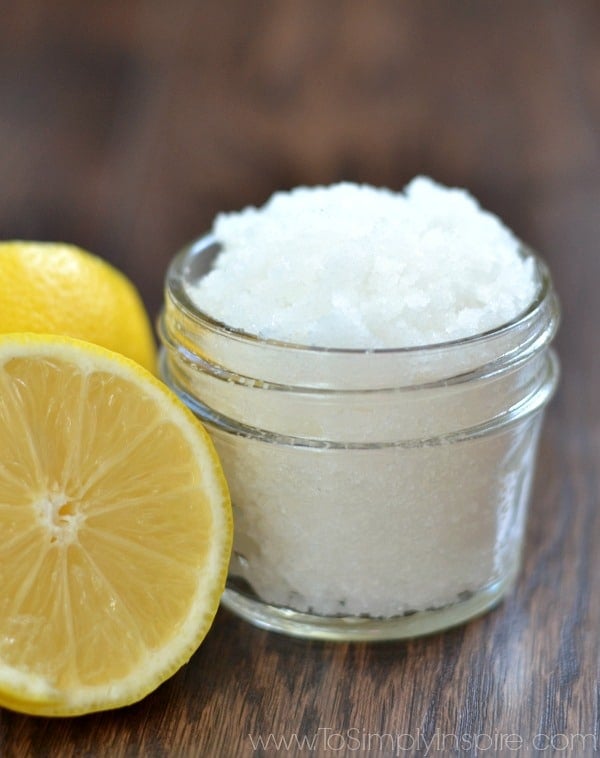 a small mason jar with lemon sugar scrub and a half a lemon beside