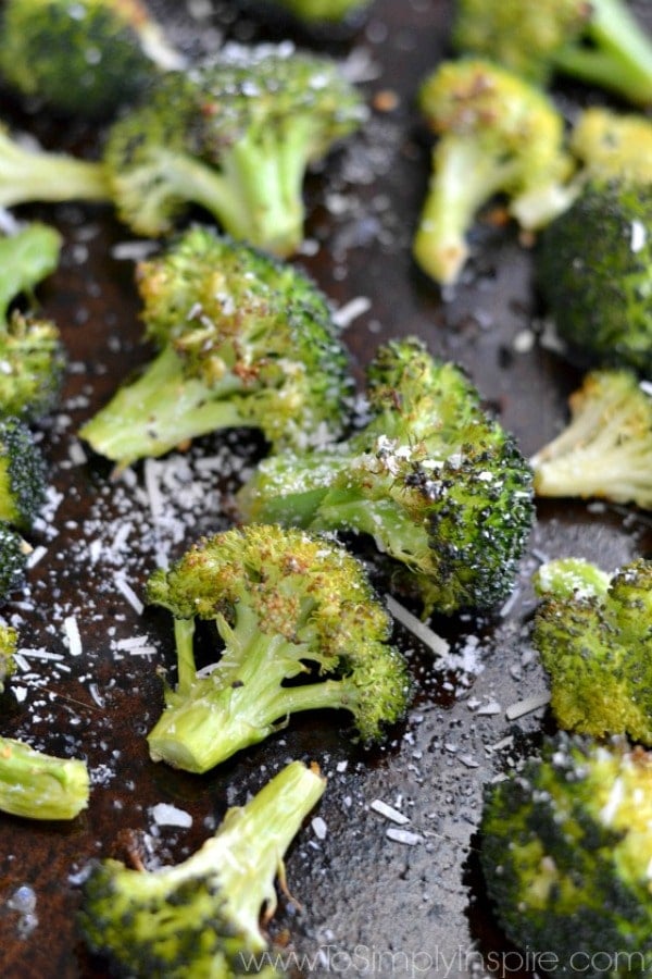 This simple roasted broccoli flavored with garlic parmesan is a fantastic healthy side dish. Quick 5 minute prep for a bursting with flavor veggie! A close up of a piece of broccoli