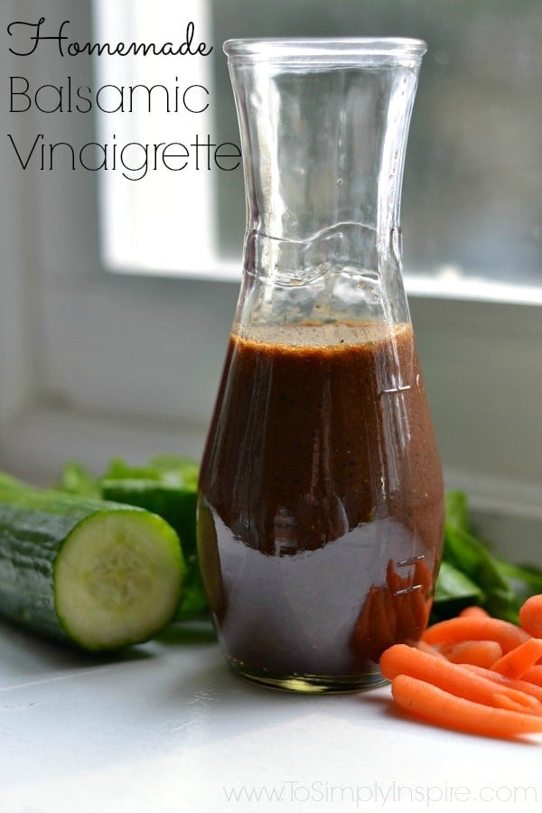 a bottle of homemade balsamic vinaigrette surrounded by fresh vegetables 