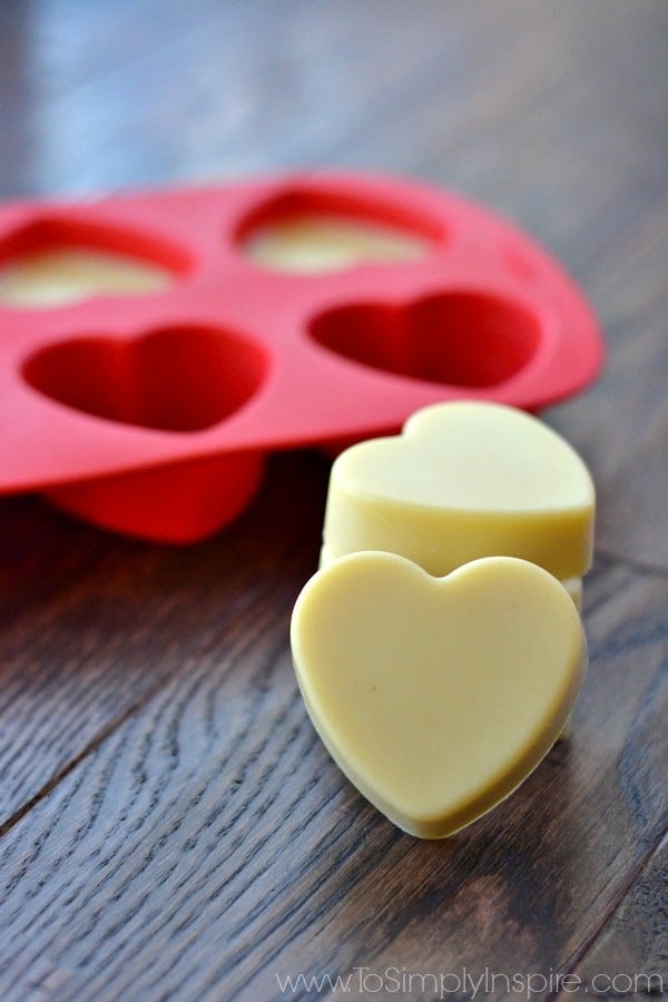 Two heart shaped lotion bars with a red silicon tray