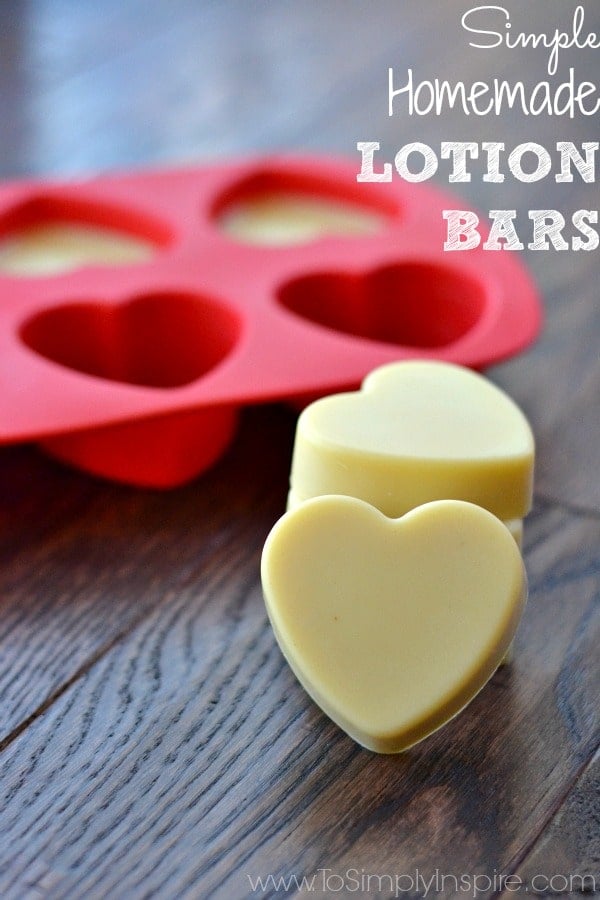 two yellow heart shaped lotion bars with a red silicon heart mold in the background