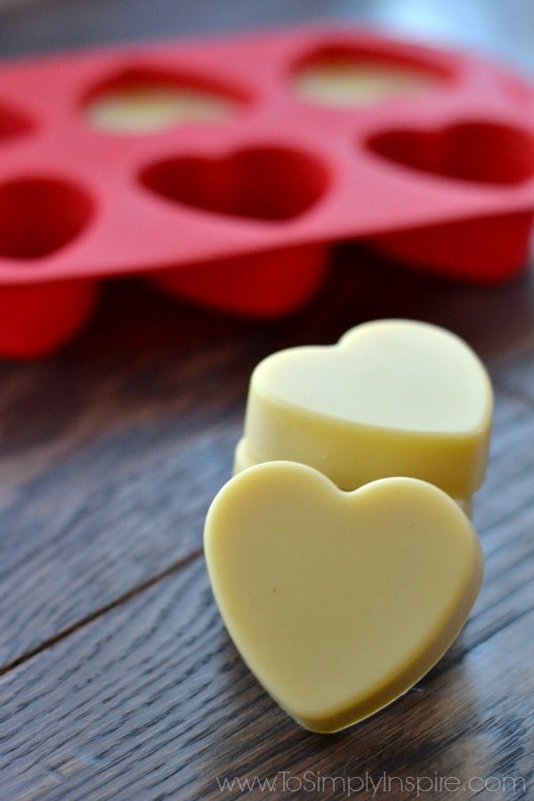 Two heart shaped lotion bars with a red silicon tray