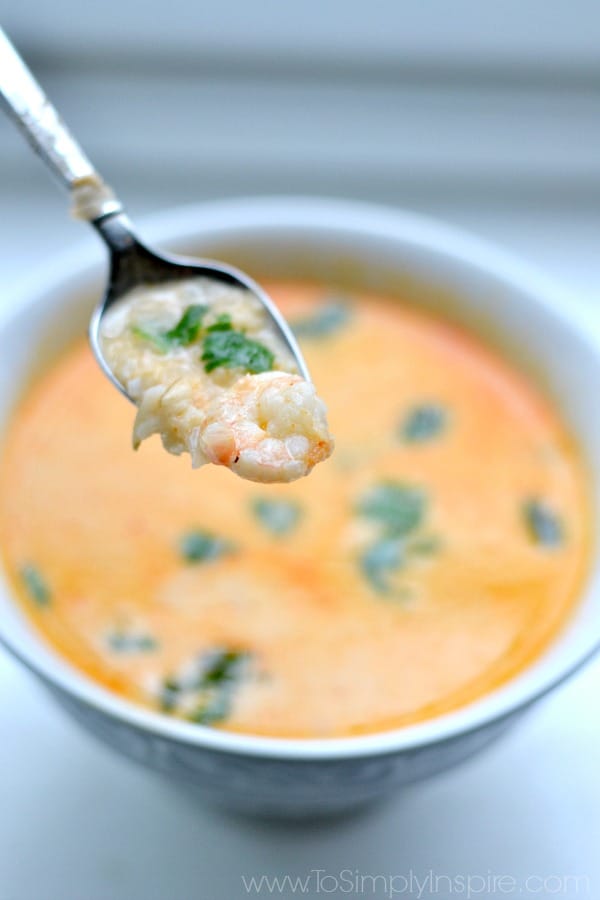a spoonful of thai shrimp soup over a white bowl
