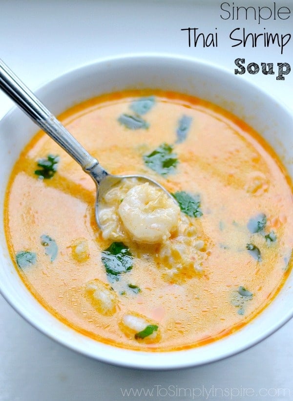 A close up of a bowl of shrimp soup with a spoon