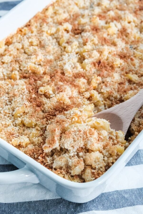 chicken casserole being scooped out of a white baking dish