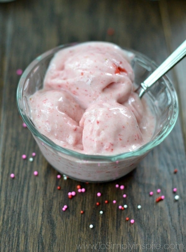 closeup of 2 ingredient Homemade Strawberry Ice Cream in a glass bowl with a silver spoon.