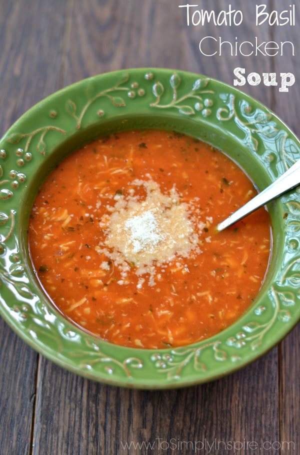 a green bowl tomato soup with topped with parmesan cheese