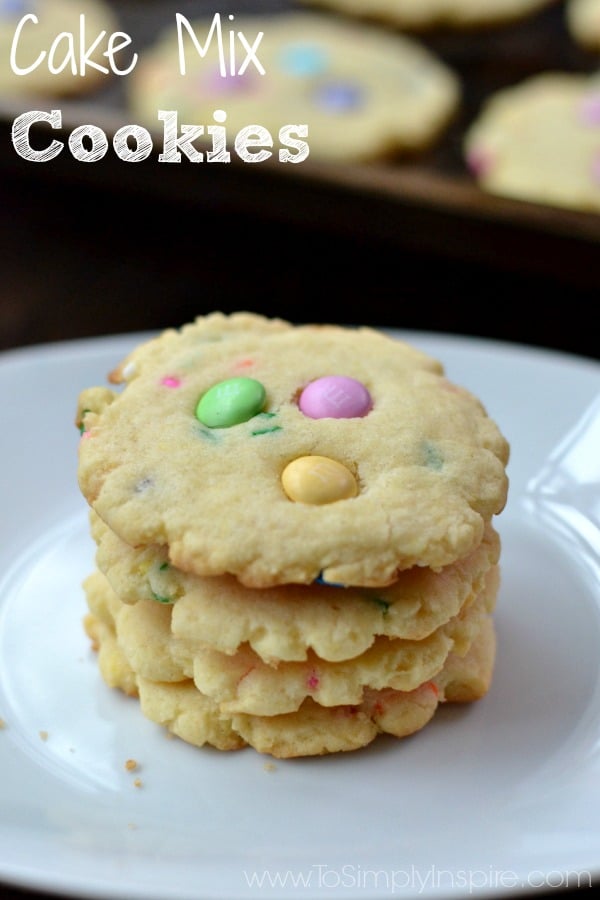 a stack of four cookies with pink, green and yellow m&m\'s