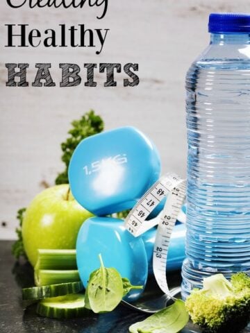 A bottle of water with blue weights and a green apple with text overlay "creating healthy habits"