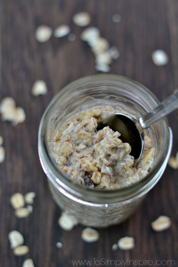 a mason jar with oatmeal and a spoon on a wood table