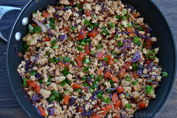 a black skillet with ground turkey, red peppers and scallions