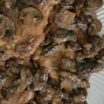 closeup of chicken marsala topped with mushrooms