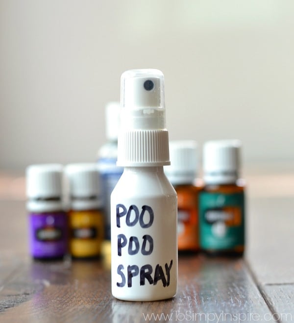 This easy recipe for homemade Poo Pourri Spray is amazing. Make your house happy and prevent those dreaded bathroom odors. a plastic bottle with four bottles of essential oils in the background