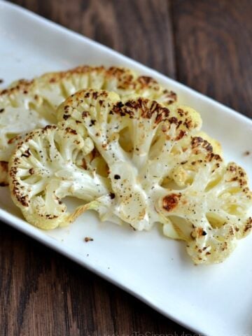 A white plate with two Cauliflower Steaks