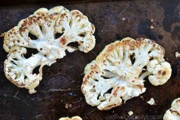 A baking sheet with two Cauliflower Steaks 