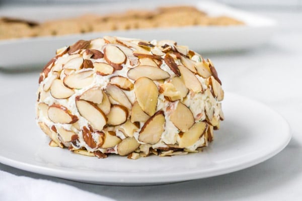 almond coated bacon cheese ball on a white plate