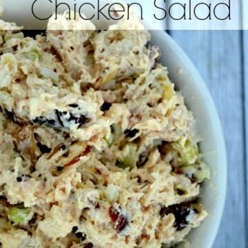 a white bowl full of chicken salad with cranberries