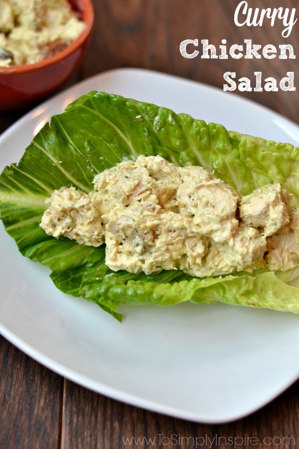 A plate of food with a piece of romaine lettuce filled with Curry chicken salad with text overlay