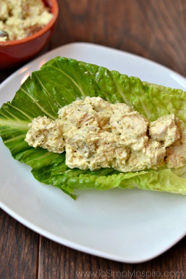 A plate of food with a piece of romaine lettuce filled with Curry chicken salad