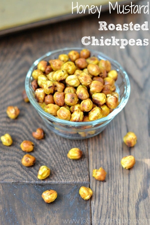 These Honey Mustard Roasted Chickpeas the most wonderful crunchy, healthy snack that everyone loves. You will love how easy and cheap they are to make too. a glass bowl with honey mustard chickpeas with text overlay