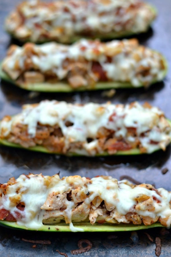 Three Zucchini Boats stuffed with Italian chicken on a baking sheet