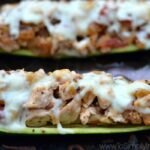 Closeup of Zucchini Boats stuffed with Italian chicken on a baking sheet