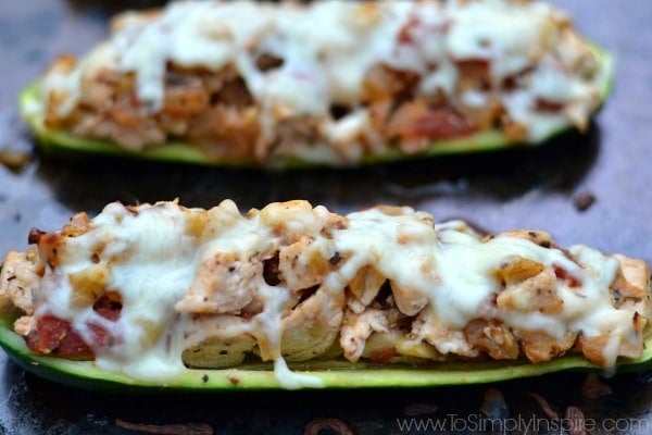 closeup of two chicken Stuffed Zucchini Boats on a baking sheet