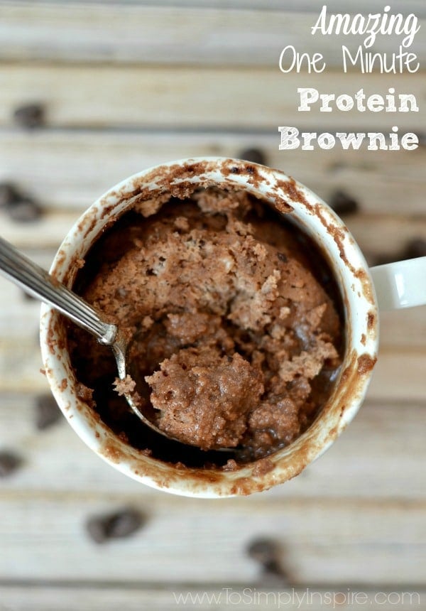 a white mug with a protein brownie and a spoon with text overlay