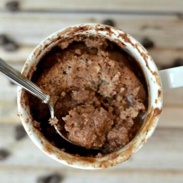 a white mug with a protein brownie and a spoon