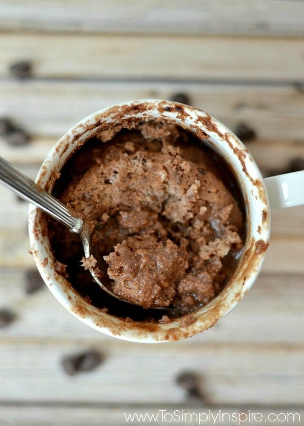 a white mug with a protein brownie and a spoon 