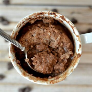 a white mug with a protein brownie and a spoon