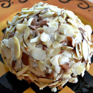 almond covered bacon dill cheeseball on a brown plate