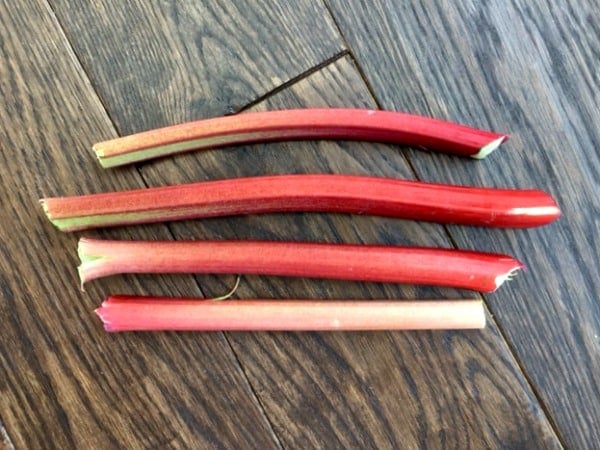 four rhubarb stalks on a wooded background