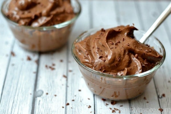 two bowls with chocolate pudding topped with shaved chocolate