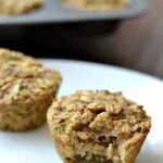 a closeup of 2 zucchini oatmeal muffins on a white plate