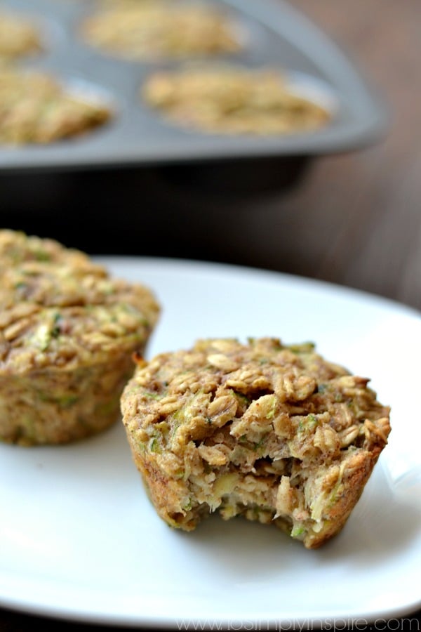 These Zucchini Banana Oatmeal Muffins are an incredible, healthy breakfast. Made with no refined sugar, oil or flour, they are wonderfully moist and perfect for on the go. a closeup of 2 zucchini oatmeal muffins on a white plate