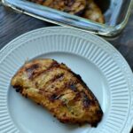 closeup of a white plate with a piece of grilled chicken breast