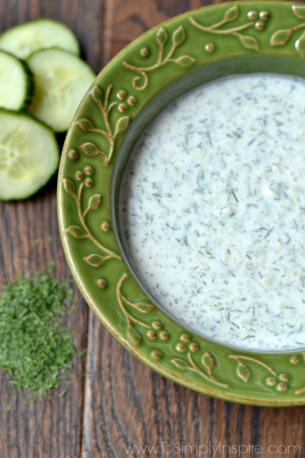 A green bowl of Cucumber Dill sauce on a wood table