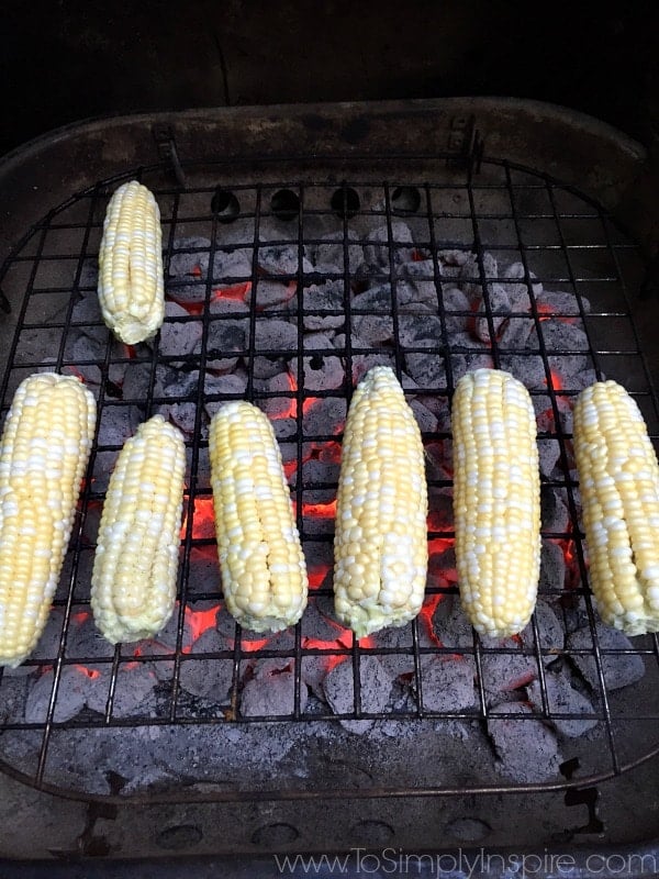 seven ears of corn cooking on a grill