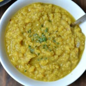 A white bowl of Lentils with a spoon